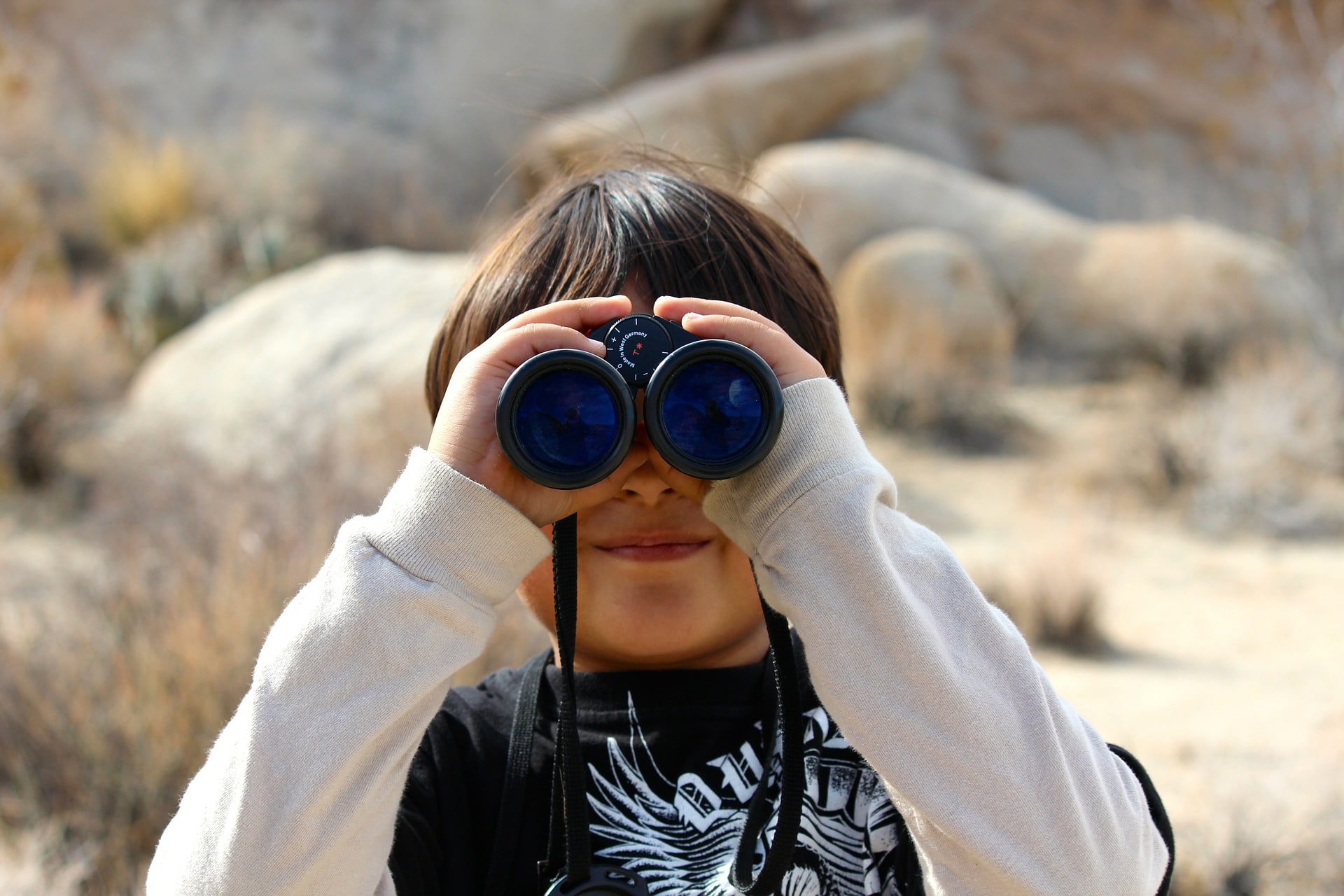 a kid looks through his binoculars 