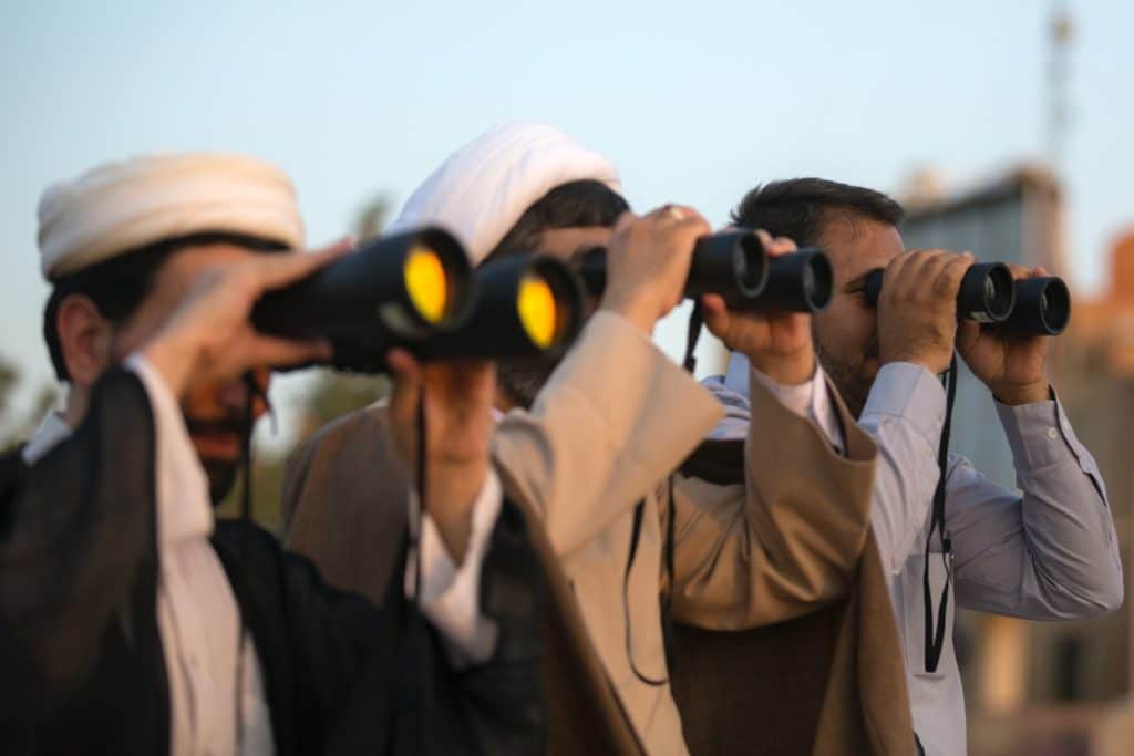 three guys looking through binocular 