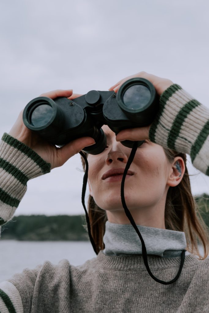 a girl looks through binocular 