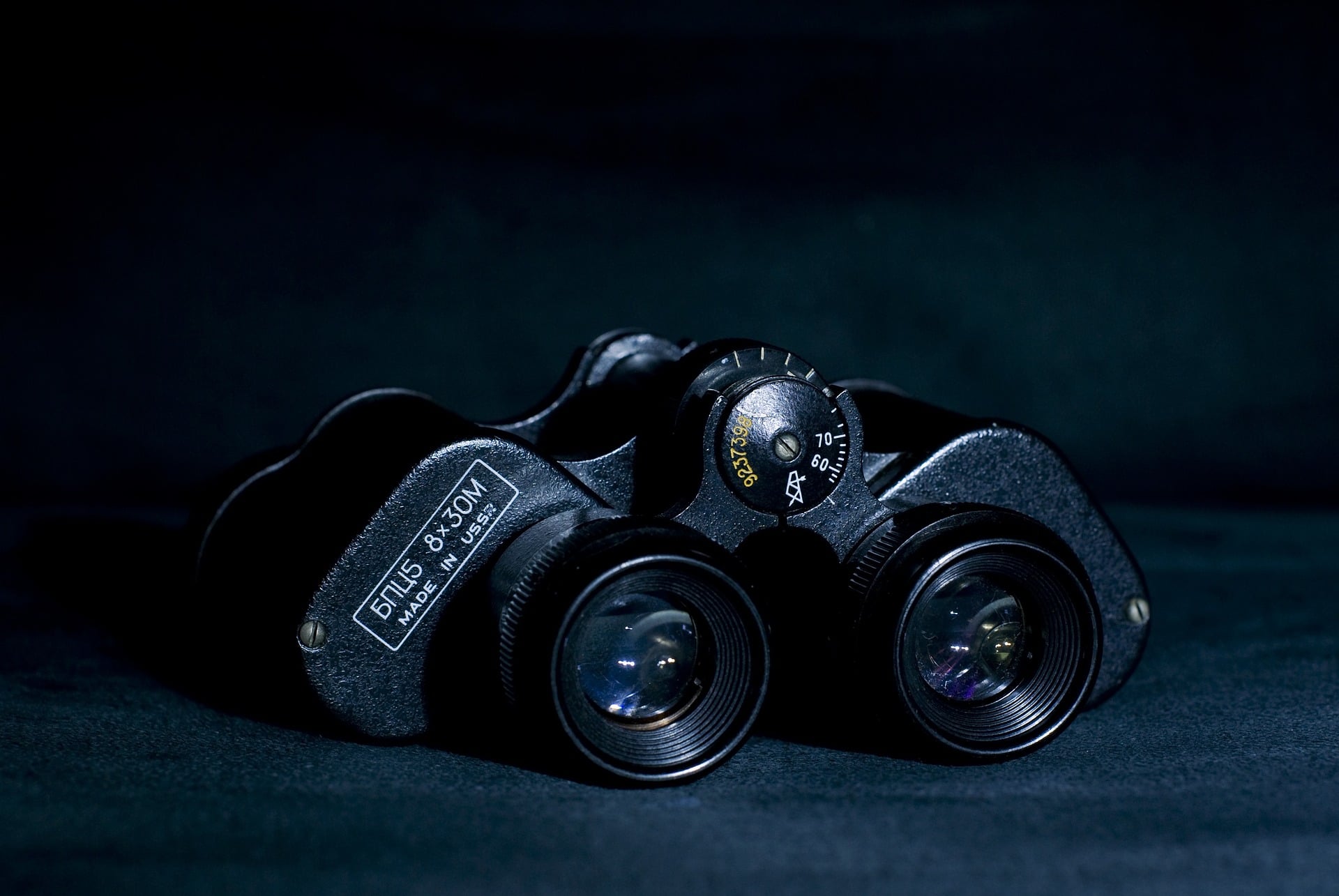 Black binoculars placed on a black surface