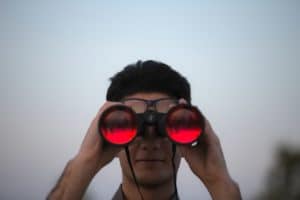 a guy look through his binocular
